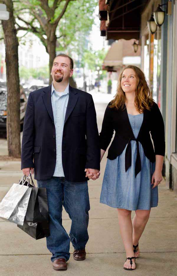 couple walking along Chicago street holding hands and smiling